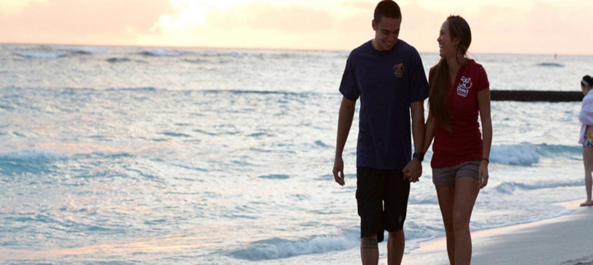 Couple walking along the beach at sunset